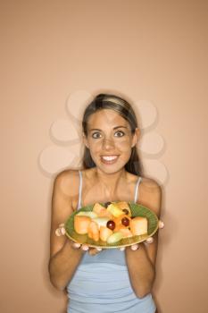 Royalty Free Photo of a Woman Holding a Plate of Fruit