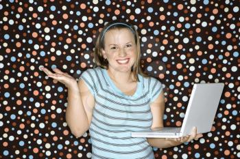 Royalty Free Photo of a Woman Holding Laptop and Shrugging