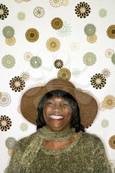 Royalty Free Photo of a Smiling Woman Standing in Front of a Vintage Pattern Background