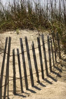 Royalty Free Photo of a Weathered Wooden Fence on a Sand Dune in Bald Head Island, North Carolina
