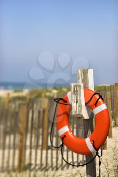 Royalty Free Photo of a Life Preserver Hanging on a Post on a Beach in Bald Head Island, North Carolina