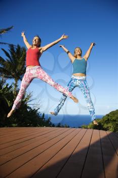 Royalty Free Photo of Women Jumping into the Air With Arms and Legs Outstretched