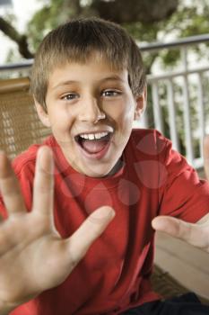 Caucasian teenage boy looking happy and excited reaching hand out.