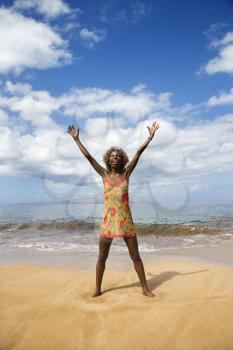 Royalty Free Photo of a Woman With Arms Outstretched on a Beach