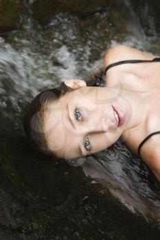 Royalty Free Photo of a Woman Laying in Freshwater Stream 