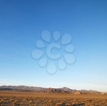 Royalty Free Photo of Barren Desert Landscape With Mountains in the Distance