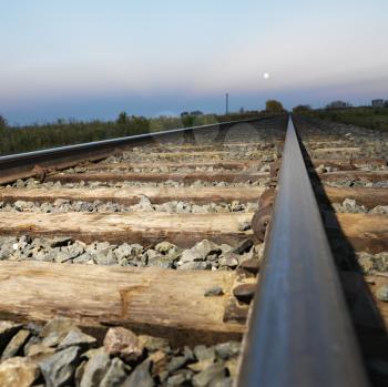 Royalty Free Photo of a Low angle diminishing view of railroad tracks in rural setting at dusk