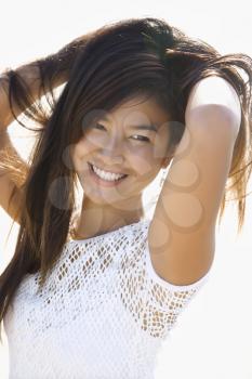 Royalty Free Photo of a Young Asian Female Holding Her Hair Up Behind Her Back