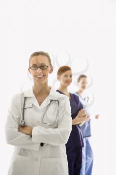 Portrait of smiling Caucasian medical healthcare workers in uniforms standing against white background.