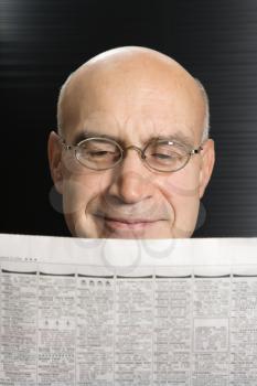 Royalty Free Photo of a Middle-aged Businessman Reading a Newspaper