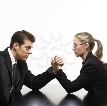 Royalty Free Photo of a Businessman and Businesswoman Arm Wrestling on a Table