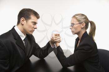 Royalty Free Photo of a Businessman and Businesswoman Arm Wrestling on a Table