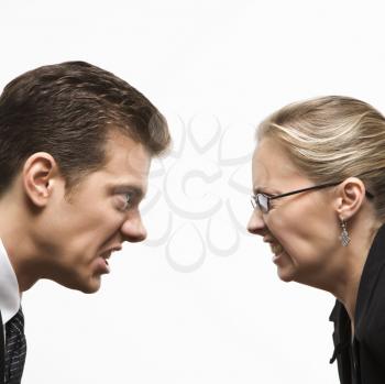 Royalty Free Photo of a Businessman and Businesswoman Staring at Each Other With Hostile Expressions