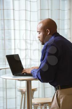 Royalty Free Photo of a Man Typing on a Laptop