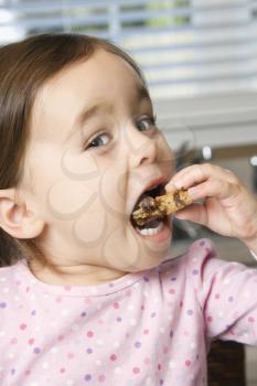Royalty Free Photo of a Girl Eating a Chocolate Chip Cookie