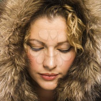 Royalty Free Photo of a Woman Wearing a Fur Hood With Her Eyes Closed