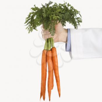Royalty Free Photo of a Male Physician Holding a Bunch of Carrots