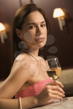 Royalty Free Photo of a Woman Sitting at a Bar With a Glass of White Wine