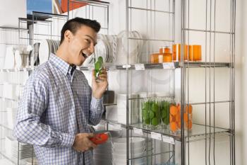 Royalty Free Photo of an Asian Male Shopping for Dishes and Glasses in a Retail Store