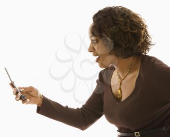 Side view of woman looking at cellphone with happy expression.