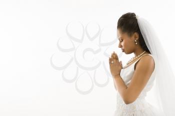 Mid-adult African-American bride praying  with white background.