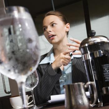 Royalty Free Photo of a Businesswoman Sitting at a Table With Coffee and beverages