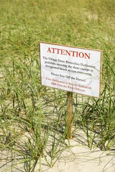 Royalty Free Photo of a Sign Warning Visitors Not to Walk on or Disturb a Natural Dune Area