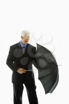 Royalty Free Photo of a Businessman Closing an Umbrella