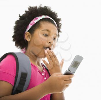 Royalty Free Photo of a Girl With Backpack Reading a Text Message From a Cellphone