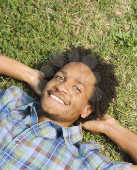 Royalty Free Photo of a Man Lying in the Grass Smiling 