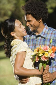 Royalty Free Photo of a Man Giving a Smiling Woman a Bouquet of Flowers