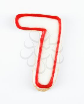 Royalty Free Photo of a Sugar Cookie in the Shape of a Number Seven Outlined in Red Icing