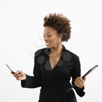 Royalty Free Photo of a Businesswoman Looking at a Cellphone Smiling