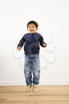 Royalty Free Photo of a Boy Jumping Up Into the Air Smiling
