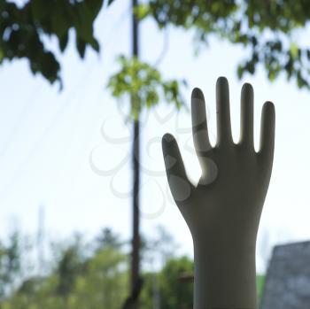 Hand statue silhouetted against sky.