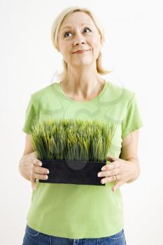 Royalty Free Photo of a Woman Holding a Pot of Grass