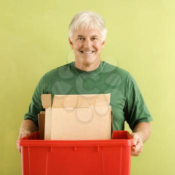 Royalty Free Photo of a Smiling Man Holding a Recycling Bin 