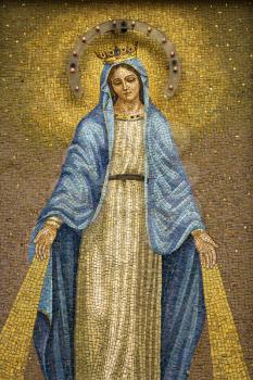 Mosaic of the Virgin Mary wearing a crown with device to give off light at night. Vertical shot.