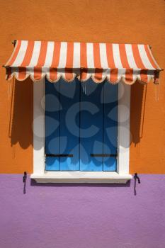 Colorful window with shutters and awning in Venice, Italy. Vertical shot.