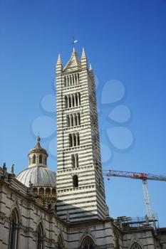 Low angle view of the Cathedral of Siena, against blue sky, in Siena, Italy. Vertical shot.