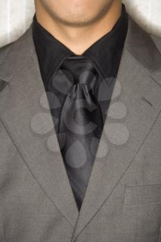 Cropped close-up of businessman's suit jacket and necktie. Vertical format.