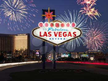 Lighted sign reading Welcome to Fabulous Las Vegas Nevada with fireworks in background. Horizontally framed shot.