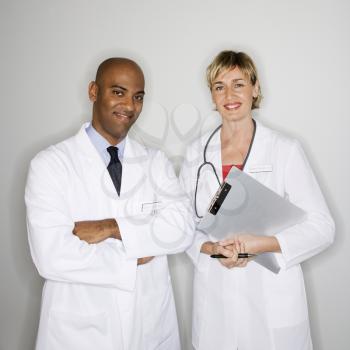 Portrait of male and female doctors standing smiling.