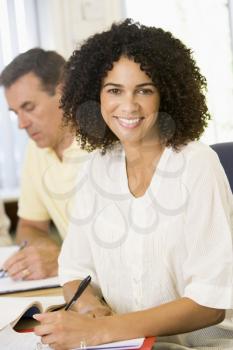 Royalty Free Photo of a Woman Taking Notes With a Man in the Background