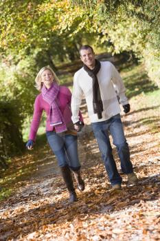 Royalty Free Photo of a Couple Running in the Park Holding Hands