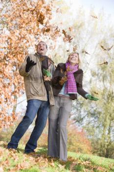 Royalty Free Photo of a Couple Playing in the Leaves