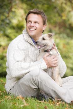 Royalty Free Photo of a Man and a Dog Sitting on the Lawn