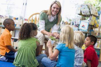 Royalty Free Photo of a Teacher Showing Her Class a Bamboo Shoot