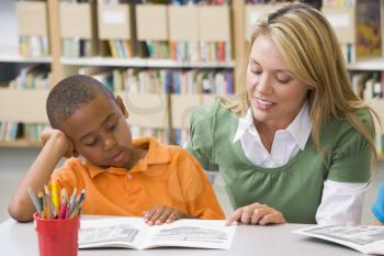 Royalty Free Clipart Image of a Student in Class Reading With a Teacher