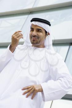 Royalty Free Photo of a Middle Eastern Man Outside an Office Building With a Headset